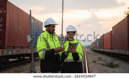 Foreman checking inventory or task details on freight train cars and shipping containers. Logistics concept, import, and export industries.