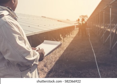 foreman checking job routine of labor working on cleaning solar panel at outside ; operation working on preventive and maintenance in solar power plant for great efficiency