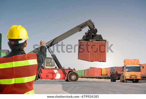 Foreman control forklift uploading truck with
fork loader, man in safety
uniform