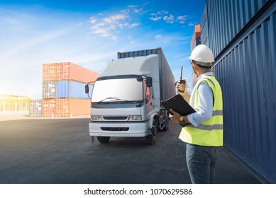 Foreman control loading Containers box from Cargo freight ship in Warehouse shipping transportation concept.