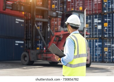 Foreman control loading Containers box from Cargo freight ship in Warehouse shipping transportation concept. - Shutterstock ID 730856782