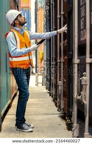 Foreman control loading containers box from factory to cargo freight ship. Container yard worker checking container at container yard warehouse. Shipping import export industry Logistics business.