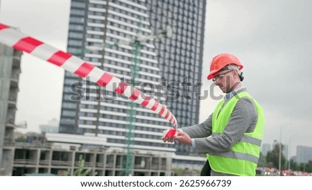 Foreman cordoning off new development site for safety purposes