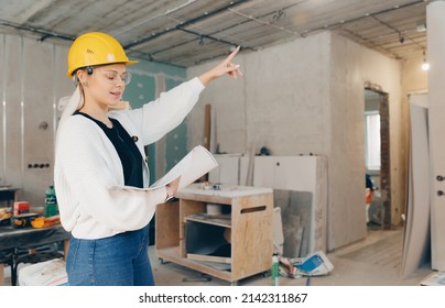 Foreman designer woman inspecting work of builder construction in apartment, checks supervision design project concept. - Shutterstock ID 2142311867