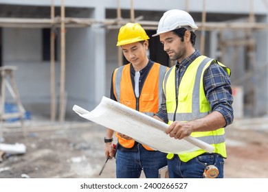 Foreman, engineer or architect with safety helmet holding laptop and blueprints for inspection details on construction in a new real estate construction site with crane and mechanical equipments. - Powered by Shutterstock