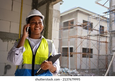 Foreman engineer women African,Afro is holding computer notebook pc tablet and talk telephone about work at Construction site to communicate to team using technology for business as professional. - Powered by Shutterstock