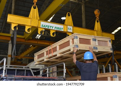 Foreman Is Giving A Signal To A Crane Move Form The Pickup.To Move The Wooden Crate  Onto The Warehouse. 