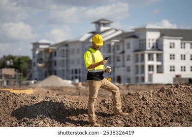 Foreman in hard hat and safety vest reviewing plans on construction site with modern building in background. - Powered by Shutterstock