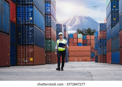 Foreman holding document, walking and checking the containers box from cargo ship for export and import