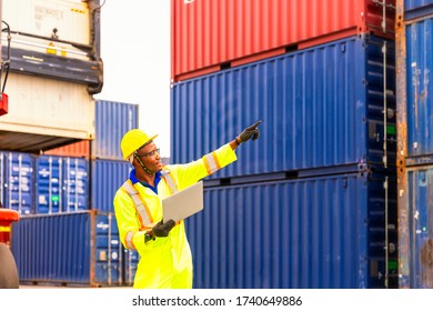 Foreman or Operator Ordering of moving containers via laptop computer. Foreman looking forword on Forklifts in the Industrial Container Cargo freight ship.
