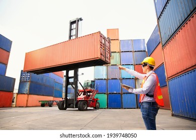 Foreman or Operator Ordering of moving containers with laptop computer. Foreman looking forward on Forklifts in the Industrial Container Cargo freight ship. Look forward.