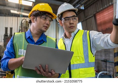 Foreman Or Professional Technician Holding A Laptop Computer In An Industrial Factory. Male Engineer Apprentice Trainee With Machine In Industrial Machinery.