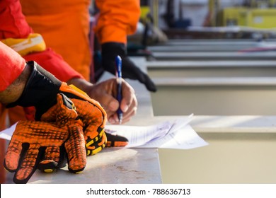 A Foreman Reviews And Put A Signature To A Safety Checklist Prior To Heavy Lifting Activity On A Construction Barge At Oil Field