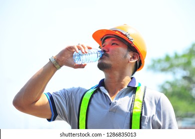 Foreman With Safety Vest And Safety Helmets Are Drinking Water.