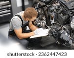 Foreman in service repair center diagnoses parts on motorcycle. Service and warranty service of concept motorcycles