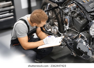 Foreman in service repair center diagnoses parts on motorcycle. Service and warranty service of concept motorcycles