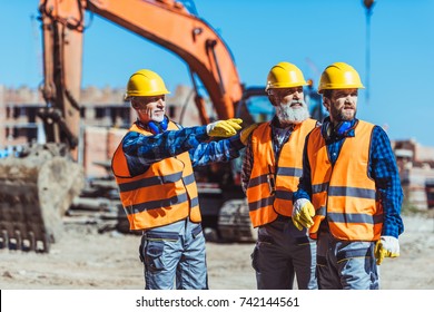 Foreman Showing Builders Something At The Construction Site By Pointing His Hand 