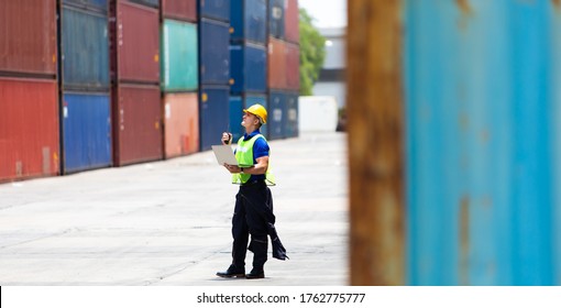 Foreman Worker Container Control Staff Is Working On Computer Laptop At Container Yard Or Cargo Containers Warehouse. Import And Export Concept