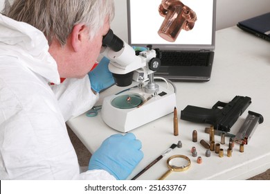 Forensic Analysis - A Forensics Lab Technician Examines A Bullet And Hand Gun For Finger Prints, Blood Splatter, And Any Other Residue Or Evidence To Be Used In A Court Case