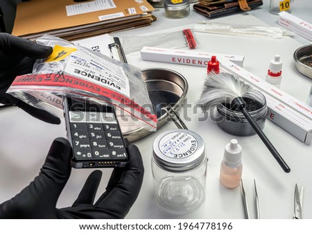 Forensic lab, forensic police take mobile from murder victim's evidence bag, conceptual image