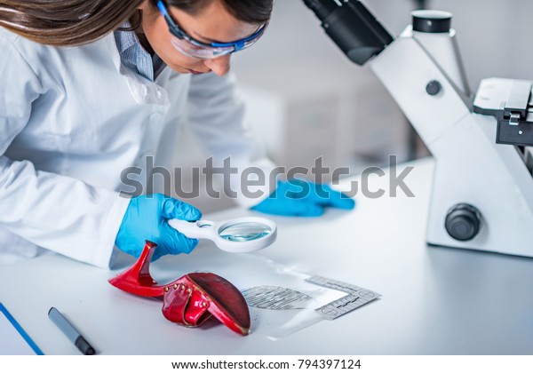 Forensic science expert examining objects from a\
crime scene