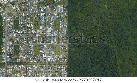 Forest and city border, forest and city separated by straight line, looking down aerial view from above – Bird’s eye view forest and city border Jardim acapulco, Guaruja - Sao Paulo, Brazil	
