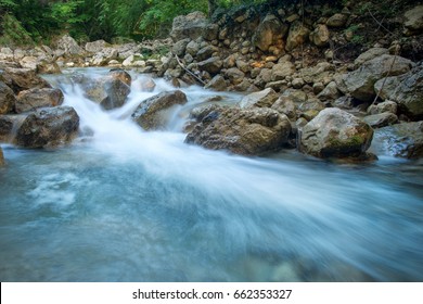 Forest creek with waterfalls. Water cascades over rocks. blue and crystal clear water in mountain river.