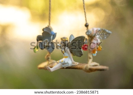 Forest fairy figure on a swing with out of focus background. magical characters for children