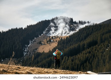 Forest fire. Solo Hiker Observing Smoke Rising From Forested Mountain Ridge in Late Afternoon. Hiking in Carpathian Mountains, Ukraine - Powered by Shutterstock