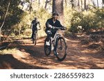 Forest, fitness and friends cyclist on bicycle in nature with helmet, exercise adventure trail and health mindset. Cycling, woods and man with mountain bike in trees for workout, motivation or energy