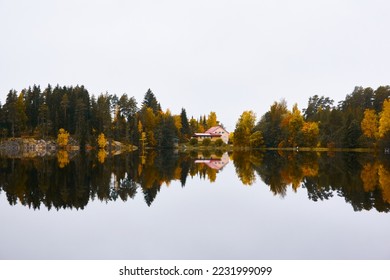Forest lake (river) on a cloudy day. Country house, cottage. Reflections in water. Gloomy sky after the rain. Finland. Idyllic autumn landscape. Pure nature, ecology, ecological reserve, ecotourism