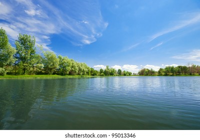 Forest Lake Under Blue Cloudy Sky