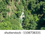 Forest river flowing between two high rocks with green plants in Georgia.  Okatse canyon.