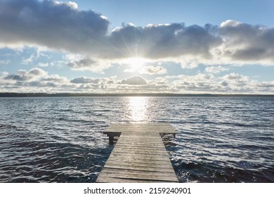 Forest river (lake) on a sunny day. Wooden pier. Idyllic landscape, rural scene. Nature, ecology, ecotourism, hiking, ecological resort, local tourism