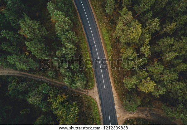 Forest road from above, Aerial view\
of a provincial road passing through a forest Riga,\
Latvia
