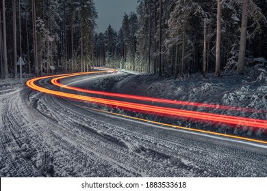 Forest Road In Winter With Car Light Trails