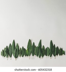 Forest treeline made of green leaves on bright background. Minimal nature concept. Flat lay.