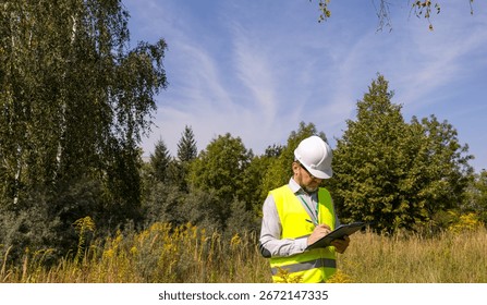 Forestry inspector studying the condition of trees in the forest. Work Ecologist. Eco control. Conducting environmental monitoring.	