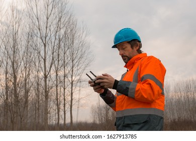 Forestry technician flying a drone with remote controller in woods and making aerial photos of forest - Powered by Shutterstock