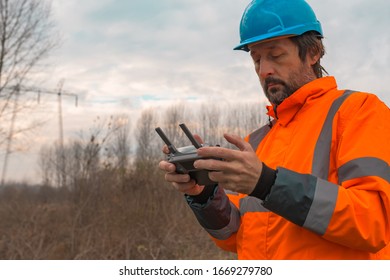 Forestry technician flying a drone with remote controller in woods and making aerial photos of forest - Powered by Shutterstock