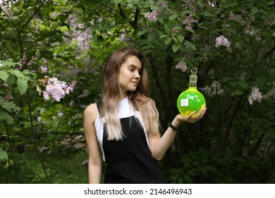 Forever Young Woman Witch, Wich Holding A Flask With Green Fluorescent Liquid In Her Hand.	
