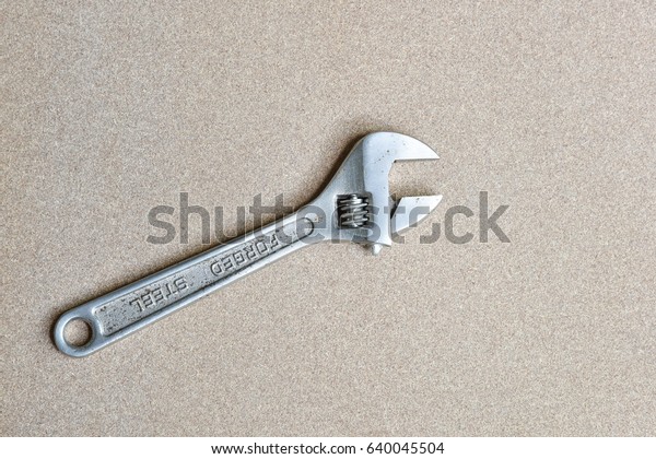 A forge adjustable wrench spanner tools lying\
on wood background