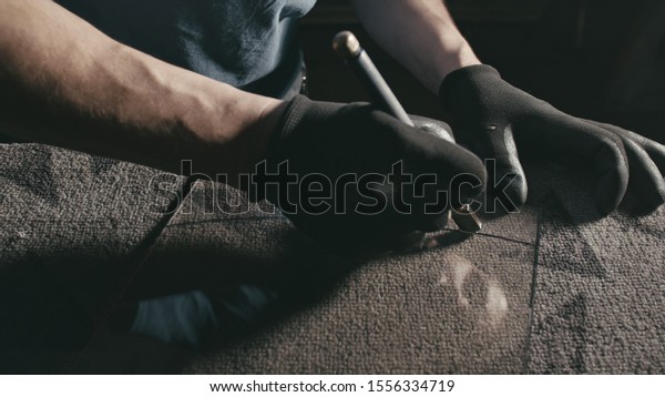 Forge. Smithy. Glass cutting and processing for\
fireplace doors. Circular glass cutter. Worker cut glass with glass\
cutting diamond. Polish an angle grinder with an abrasive circular\
disk nozzle.