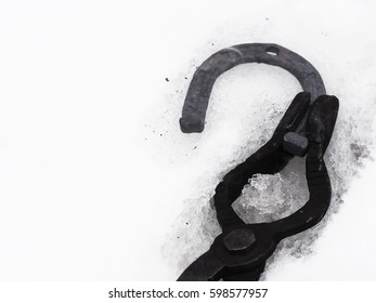 Forge: tongs for hot forging with horseshoe. Cooling the red-hot horseshoe in the snow. Snow melts from the heat of the horse shoe - Powered by Shutterstock