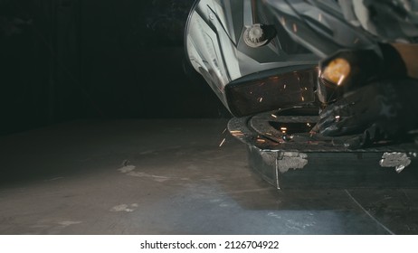 Forge Workshop. Smithy. Worker In A Welding Hood Helmet Welds A Part By Electric Welding. Sparks Are Reflected In The Protective Screen. Blacksmith Makes Iron Product For Manufacture. Slow Motion.