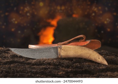 Forged finished knife on a wooden block against the background of fire in the forge. Close-up. Copy space. Handmade - Powered by Shutterstock