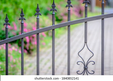 Forged iron fence (grey painted metal) at the entrance of the yard.
