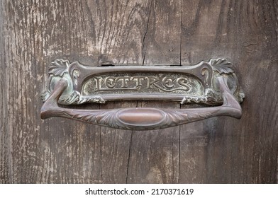 Forged metal hole for mail with lettres inscription. Old iron slot for mail on hard wood weathered door close-up. Mailbox hole for correspondence decorated ornament. Translation: Lettres means Letters - Powered by Shutterstock