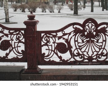 Forged painted lattice on the background of a park in the snow