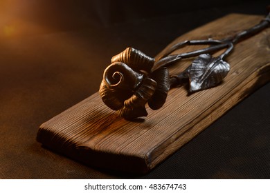 Forged rose of steel on a wooden board - Shutterstock ID 483674743